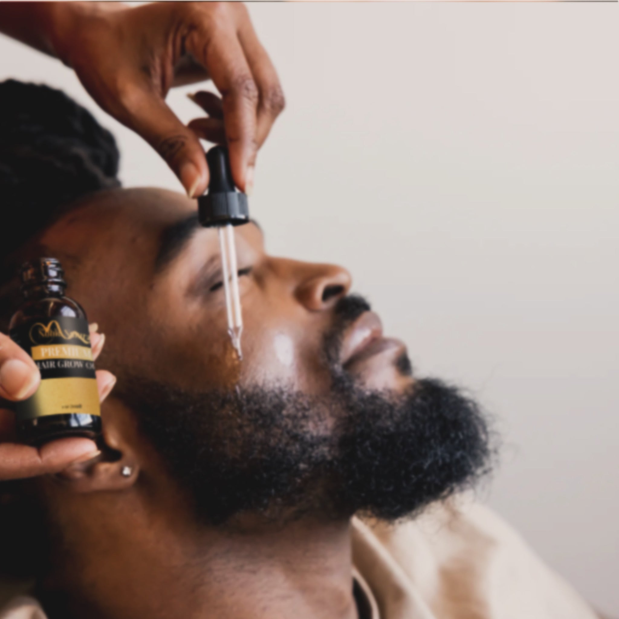 Person applying a dropper of oil to beard with The Noble Naturals.