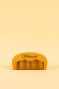 A wooden grooming comb engraved with the Noble Naturals™ logo, designed for natural hair care and healthy scalp maintenance.